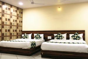 two beds in a hotel room with two at Maruti Group of Hotels - Shri Naman in Nāthdwāra