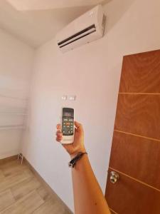 una persona sosteniendo un celular en una habitación en Casa Mochileros Anonimos, en El Guayabo