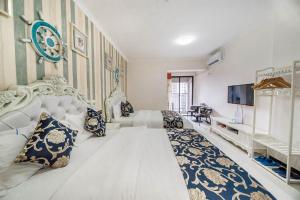 1 dormitorio con 1 cama blanca grande y TV en Pazhou Yi Xiu Boutique Apartment en Cantón