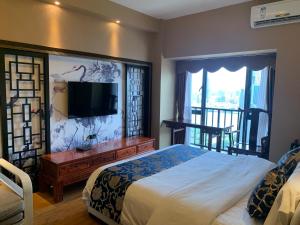 1 dormitorio con 1 cama grande y TV en Pazhou Yi Xiu Boutique Apartment en Cantón