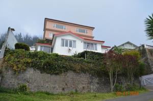 a white house behind a stone wall at Mystical Medows in Ooty