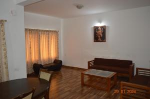 a living room with a couch and a table at Mystical Medows in Ooty