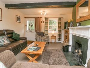 a living room with a couch and a fireplace at Nook Cottage in Keswick