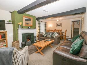 a living room with a couch and a fireplace at Nook Cottage in Keswick