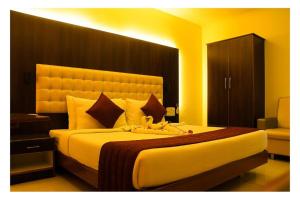 ein Schlafzimmer mit einem großen Bett mit einem großen Kopfteil in der Unterkunft Hotel SR Tiruchendur in Tiruchchendūr