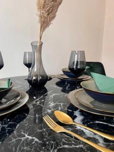 a black table with plates and glasses and a vase at Luxus Apartment in Vienna