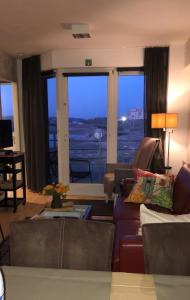 a living room with a couch and a large window at les terrasses2 in Ostend