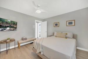 een witte slaapkamer met een bed en een tafel bij Night Lights at De Haven in St. Augustine