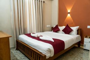 DREAMS PARADISE AIRPORT RESIDENCY في نيدومباسيري: غرفة نوم عليها سرير وفوط
