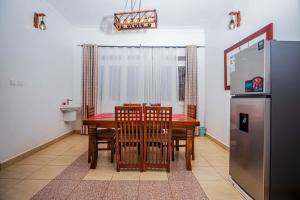 a dining room with a table and a refrigerator at MUTIMA VILLA in Jinja