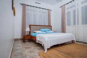 a bedroom with a bed and a large window at MUTIMA VILLA in Jinja