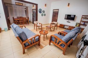 a living room with several chairs and a television at MUTIMA VILLA in Jinja