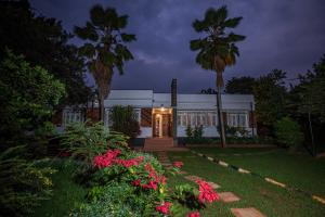 a house at night with flowers in the yard at MUTIMA VILLA in Jinja