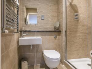 a bathroom with a toilet and a sink and a shower at Golden Sands in St Ives +23 photos