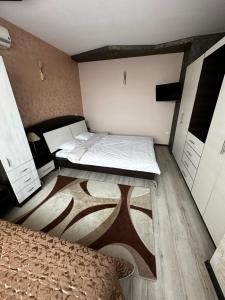 a small bedroom with two beds and a wooden floor at KK Apartments in Stara Zagora