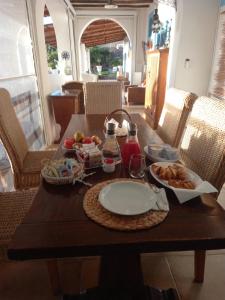 una mesa de madera con un plato de comida. en Villa Anna Salina en Santa Marina Salina