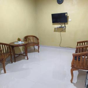 - un salon avec 2 chaises, une table et une télévision dans l'établissement Lovetogy homestay, à Sungailiat