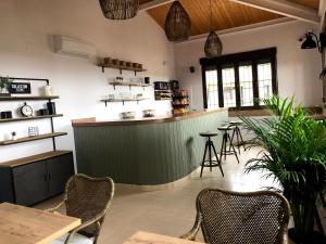 un restaurante con un bar verde con mesas y sillas en Finca Alarcos en Valverde