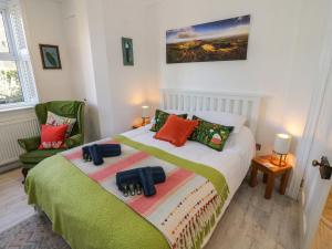 a bedroom with a bed and a green chair at The Escape in Great Malvern