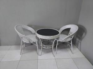 two wicker chairs and a table in a room at ROOMSTAY BIENA SANA in Pekan