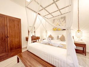 una camera con un letto bianco a baldacchino di Sinergi Seminyak, New & Quiet Spacious Villa a Seminyak