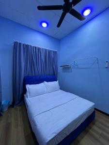 Camera blu con letto e ventilatore a soffitto. di D’wokah Roomah Pool & Space a Ketereh