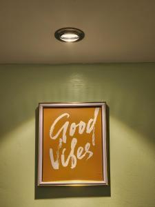 a sign that says good vibes on a green wall at Wanderlust Haven in Thika