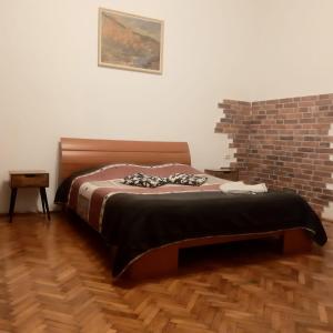 a bed in a room with a brick wall at APARTMENT POPS in Cluj-Napoca