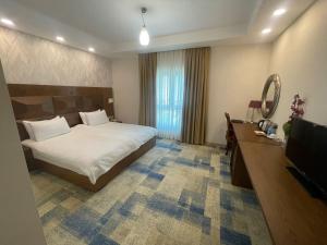 Habitación de hotel con cama y TV en Fiori Hotel en Erbil