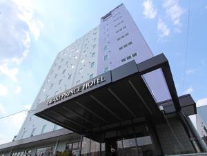 een groot wit gebouw met een bord erop bij Iwaki Prince Hotel in Iwaki