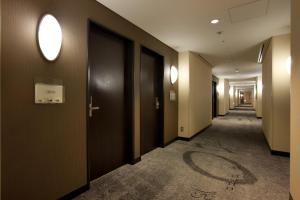 a corridor of a building with brown walls at The Royal Park Hotel Iconic Tokyo Shiodome in Tokyo