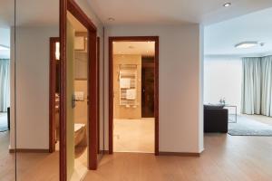 un couloir avec une porte menant à une salle de bains. dans l'établissement Hotel EDELWEISS Berchtesgaden Superior, à Berchtesgaden