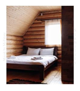 um quarto com uma cama num chalé de madeira em Mayak Chalet Resort Mykulychyn em Mykulychyn