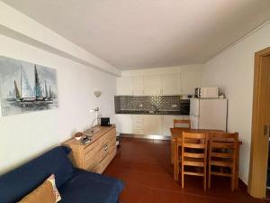 ein Wohnzimmer mit einem blauen Sofa und einer Küche in der Unterkunft Cadete house in Albufeira