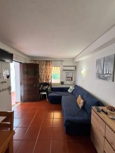 ein Wohnzimmer mit einem blauen Sofa und einer Küche in der Unterkunft Cadete house in Albufeira