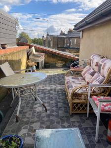 a patio with chairs and a table on a roof at Broxbourne Two-Bedroom Apartment Close To Amenities in Hoddesdon