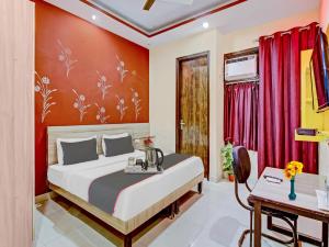 a bedroom with a bed and a red wall at Rose residency in New Delhi