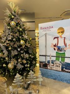 Un arbre de Noël dans un centre commercial avec un panneau dans l'établissement Ramada By Wyndham İstanbul Taksim, à Istanbul