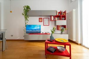 a living room with a red table and a tv at appartamento a 500 metri da San Siro in Milan