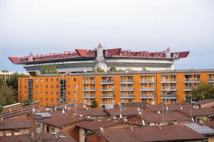 a large orange building with a round building in the background at appartamento a 500 metri da San Siro in Milan