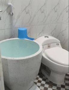 La salle de bains est pourvue de toilettes avec un couvercle bleu. dans l'établissement Lovetogy homestay, à Sungailiat