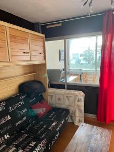 una camera con un letto, un tavolo e una finestra di les caravelles plage sud a Le Grau-du-Roi
