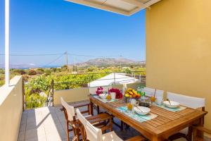 a dining room with a table and chairs on a balcony at Villa Arda in Litsárdha