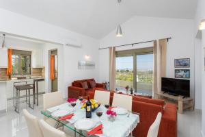 a dining room and living room with a table and chairs at Villa Arda in Litsárdha