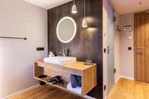 uma casa de banho com um lavatório e um espelho em BOLLWERK Lifestyle Hotel, automatisiertes Hotel mit Self Check In em Immenstadt im Allgäu