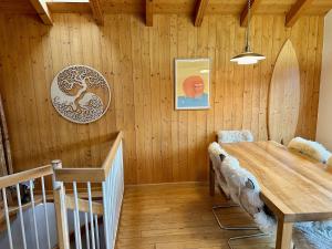 uma sala de jantar com uma mesa e uma parede de madeira em Chalet typique du Valais,Maison bio et bien-être! em Chermignon-dʼen Haut