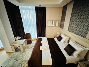 a hotel room with a large bed and a large window at HOTEL MINERO in Tuzla