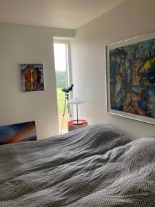 une chambre avec un lit et un tableau au mur dans l'établissement Lovely Holiday Apartment At Lübker Golf Resort, à Nimtofte