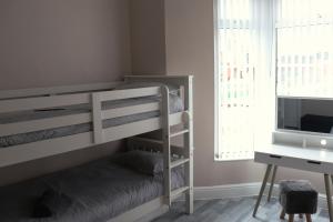 a bedroom with a bunk bed and a desk at Kop View in Liverpool