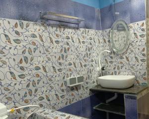uma casa de banho com um lavatório e um espelho em Talpona Beach Studios em Magdāl